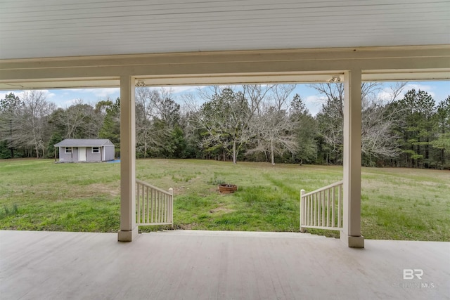 view of patio with an outbuilding, a storage shed, and a fire pit