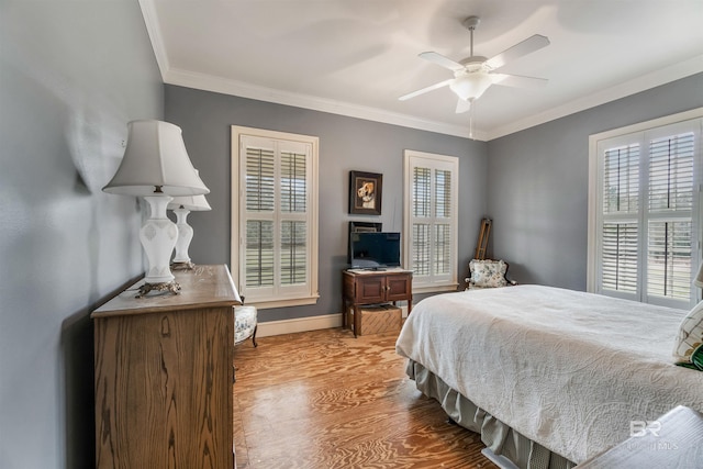 bedroom featuring baseboards, ceiling fan, wood finished floors, and crown molding