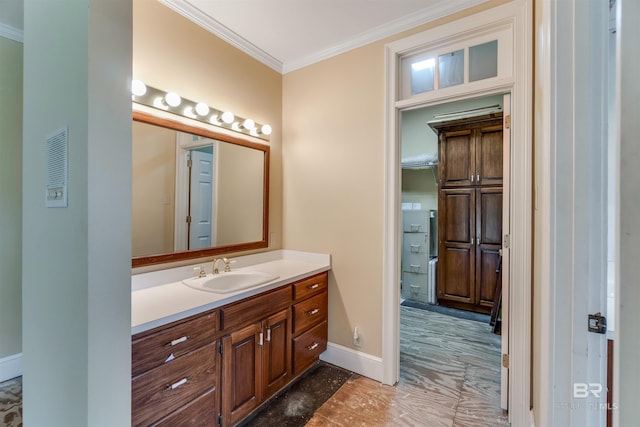 bathroom with ornamental molding, vanity, and baseboards