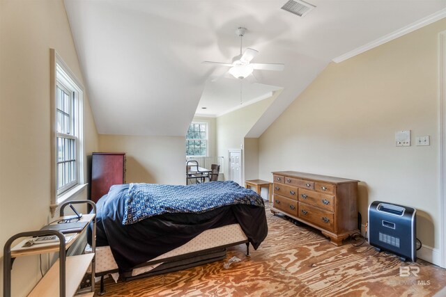 bedroom featuring lofted ceiling, a ceiling fan, visible vents, and crown molding