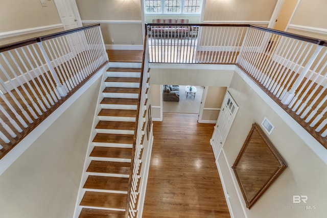 staircase featuring visible vents and wood finished floors