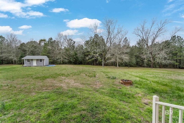 view of yard featuring an outdoor fire pit and an outbuilding
