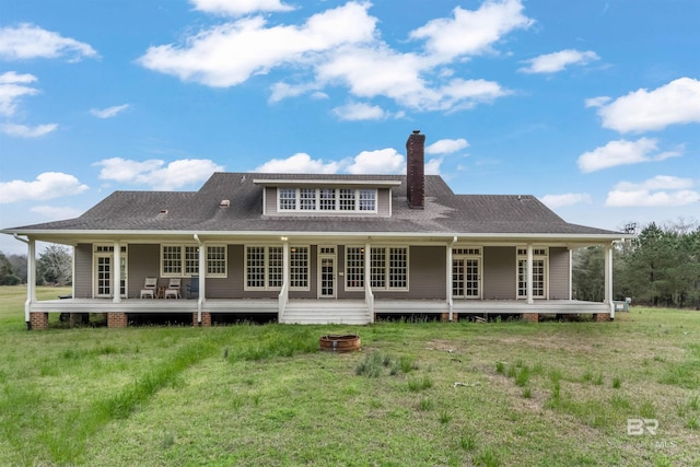 back of house featuring a deck, a yard, and a chimney