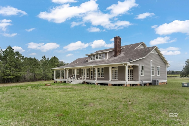 back of property with a shingled roof, a lawn, a chimney, central air condition unit, and a porch