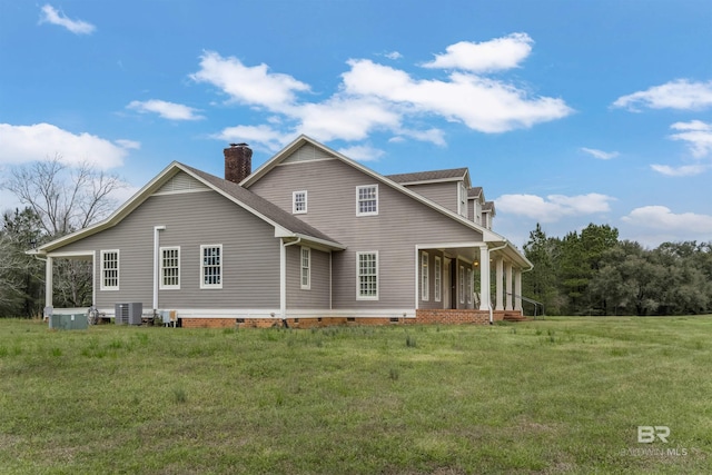 rear view of house with crawl space, a lawn, a chimney, and central air condition unit