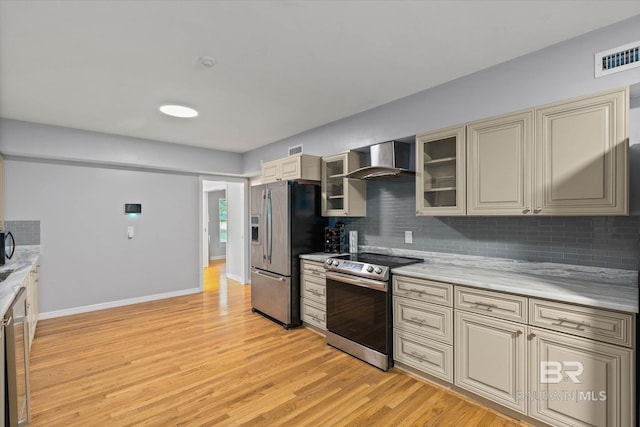 42 W Lourando Dr, Mobile, AL 36606 - kitchen with appliances with stainless steel finishes, wall chimney exhaust hood, cream cabinetry, tasteful backsplash, and light countertops