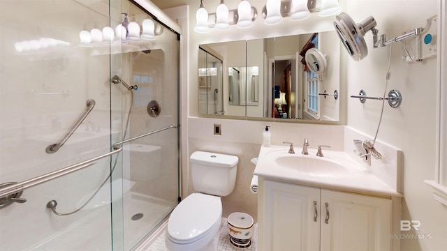 bathroom featuring vanity, toilet, and a shower with shower door