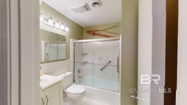 full bathroom featuring vanity, bath / shower combo with glass door, and toilet