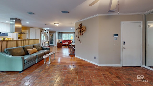 living room with ceiling fan and ornamental molding