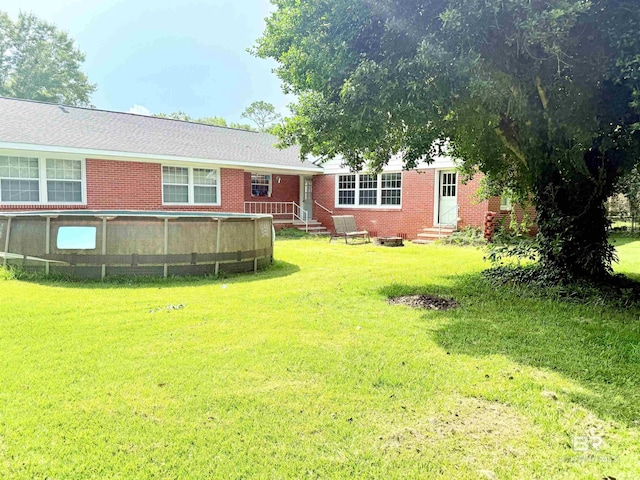 613 S Carney St, Atmore, AL 36502 - view of green lawn featuring entry steps and an outdoor pool