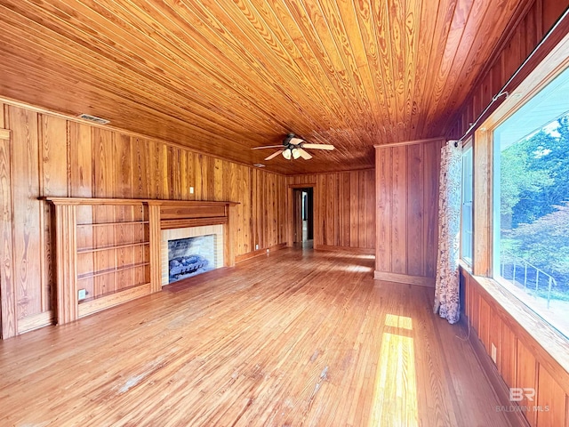 613 S Carney St, Atmore, AL 36502 - unfurnished living room with wood ceiling, wood walls, ceiling fan, hardwood / wood-style floors, and a tile fireplace