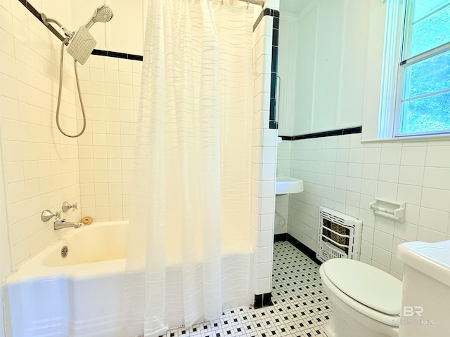 613 S Carney St, Atmore, AL 36502 - bathroom with heating unit, shower / tub combo, tile walls, and tile patterned floors