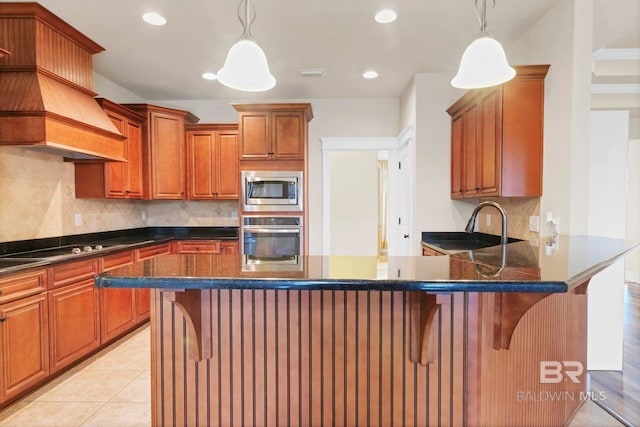 kitchen featuring appliances with stainless steel finishes, a breakfast bar, and pendant lighting