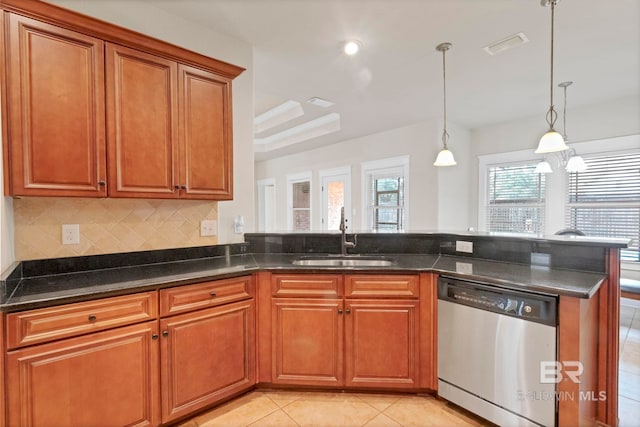 kitchen featuring decorative light fixtures, sink, dark stone countertops, backsplash, and stainless steel dishwasher