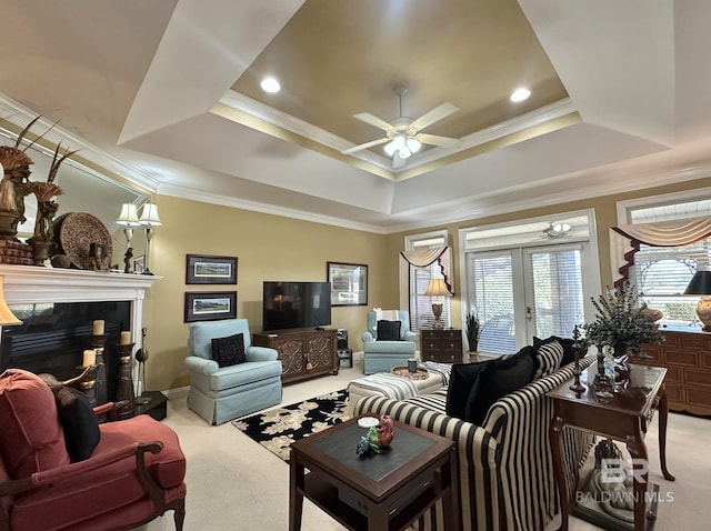 living room with light carpet, french doors, a raised ceiling, ceiling fan, and crown molding