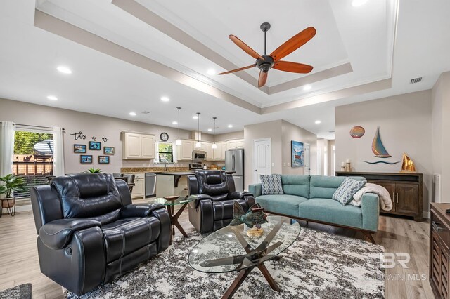 26635 Terry Cove Dr, Orange Beach, AL 36561 - living area featuring a tray ceiling, crown molding, recessed lighting, visible vents, and light wood-style flooring