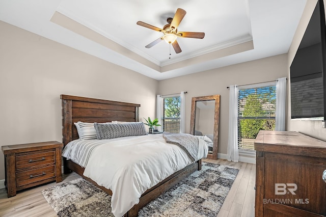 26635 Terry Cove Dr, Orange Beach, AL 36561 - bedroom featuring ceiling fan, baseboards, light wood-style floors, a tray ceiling, and crown molding