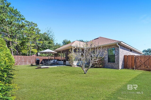 26635 Terry Cove Dr, Orange Beach, AL 36561 - rear view of property with a yard, a patio, brick siding, and a fenced backyard