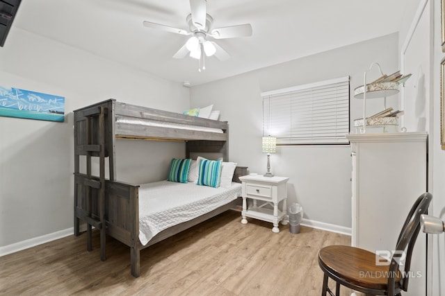 bedroom featuring baseboards, wood finished floors, and a ceiling fan