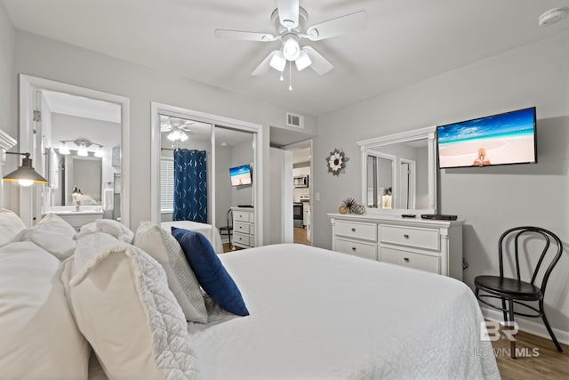 bedroom with a ceiling fan, wood finished floors, visible vents, and a closet