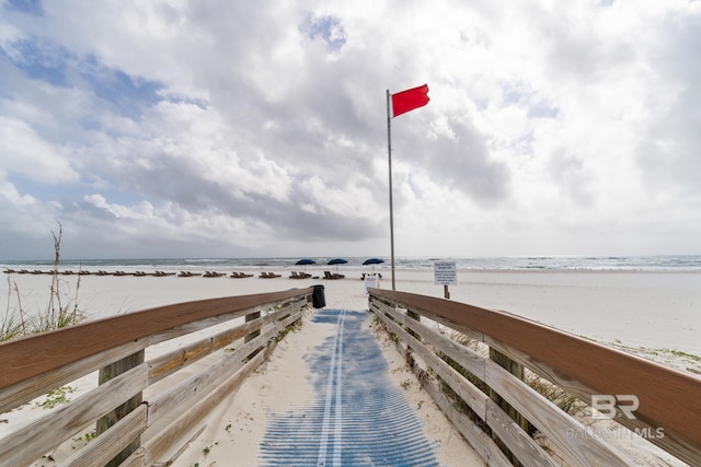 dock area with a beach view and a water view