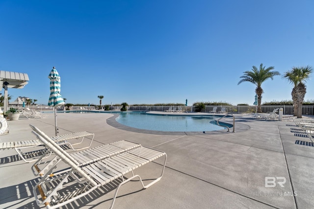 pool with a patio and fence