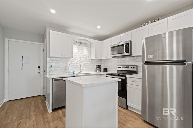 kitchen featuring a sink, stainless steel appliances, a center island, and light wood finished floors