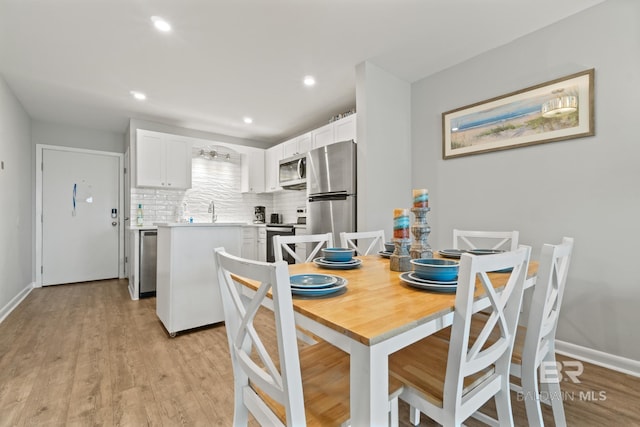 dining space featuring recessed lighting, baseboards, and light wood finished floors