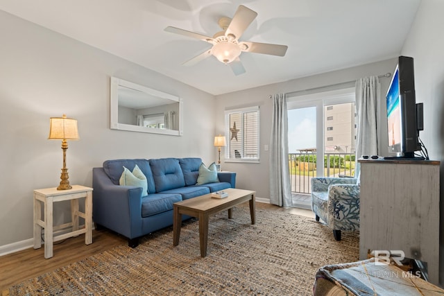 living room featuring baseboards, ceiling fan, and wood finished floors