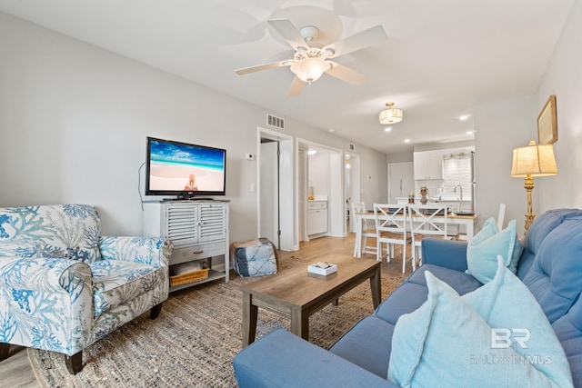 living area with recessed lighting, visible vents, light wood finished floors, and ceiling fan