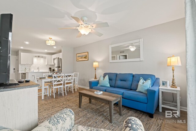 living room with recessed lighting, baseboards, a ceiling fan, and wood finished floors