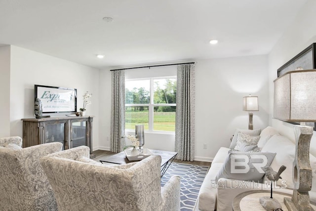living room with wood finished floors, baseboards, and recessed lighting