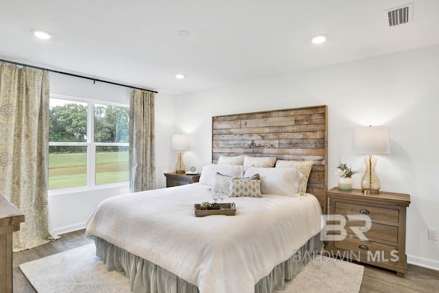 bedroom featuring wood finished floors, baseboards, and recessed lighting