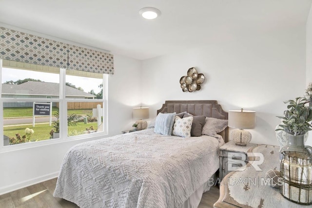 bedroom with wood finished floors and baseboards