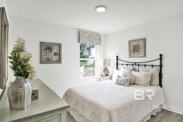 bedroom featuring wood finished floors and baseboards