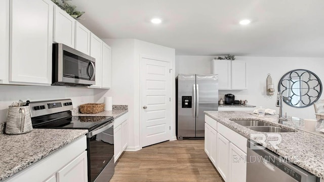 kitchen with appliances with stainless steel finishes, light wood-type flooring, white cabinetry, and recessed lighting