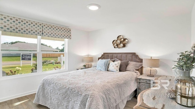 bedroom with wood finished floors and baseboards