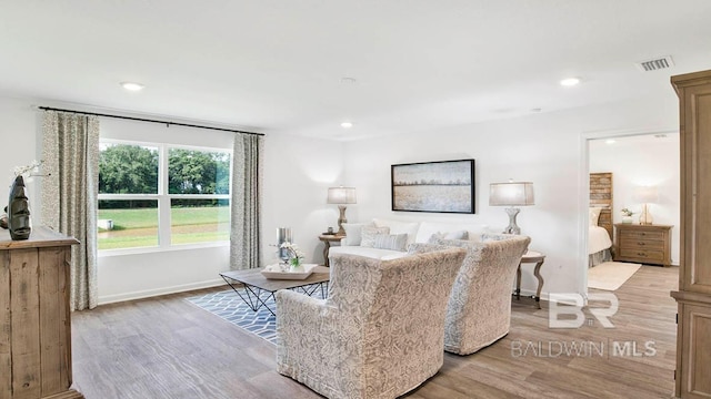 living area with light wood-type flooring, baseboards, and recessed lighting
