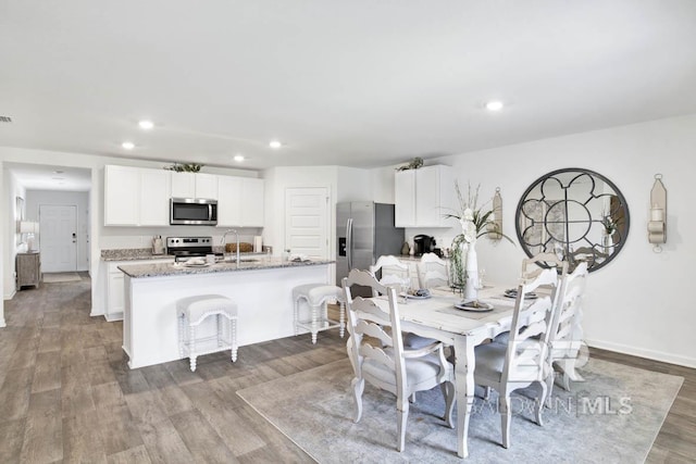 dining space with recessed lighting, wood finished floors, and baseboards