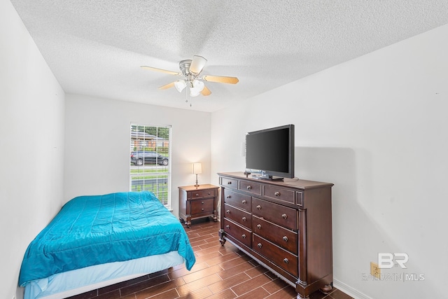 bedroom featuring ceiling fan, dark hardwood / wood-style flooring, and a textured ceiling