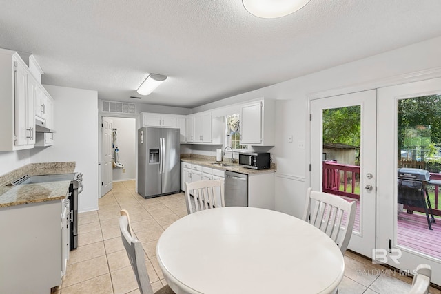 kitchen with white cabinets, stainless steel appliances, a textured ceiling, and sink