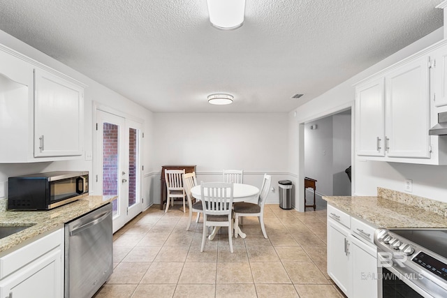 kitchen featuring white cabinets, stainless steel appliances, a textured ceiling, and french doors