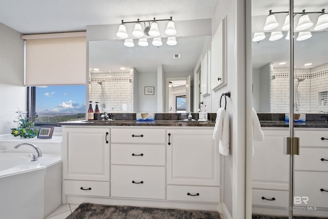 full bathroom featuring a garden tub, tile patterned flooring, a sink, a stall shower, and double vanity