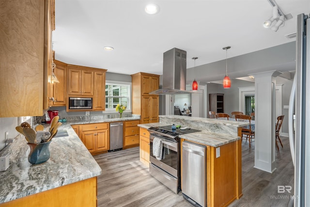 20011 Lawrence Rd, Fairhope, AL 36532 - kitchen with stainless steel appliances, island range hood, light wood-style flooring, light stone counters, and recessed lighting