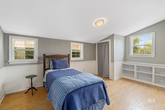 20011 Lawrence Rd, Fairhope, AL 36532 - bedroom with wood finished floors, vaulted ceiling, a wainscoted wall, and multiple windows