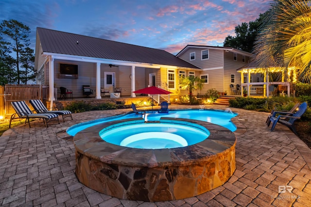 20011 Lawrence Rd, Fairhope, AL 36532 - pool at dusk with an in-ground hot tub, a patio, an outdoor pool, ceiling fan, and a gazebo
