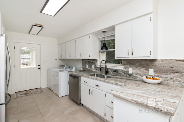 washroom with sink, washer and clothes dryer, cabinets, and light tile patterned flooring