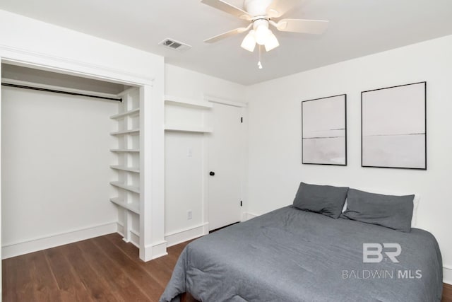 bedroom featuring ceiling fan, dark hardwood / wood-style floors, and a closet