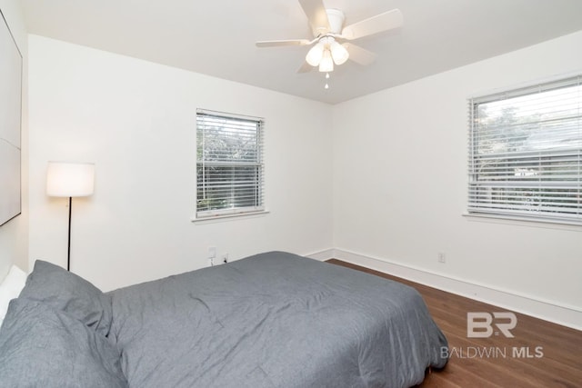 bedroom with dark hardwood / wood-style flooring and ceiling fan