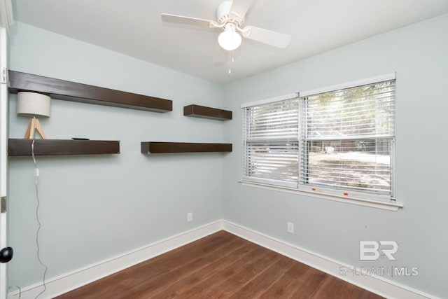 empty room featuring dark hardwood / wood-style flooring and ceiling fan